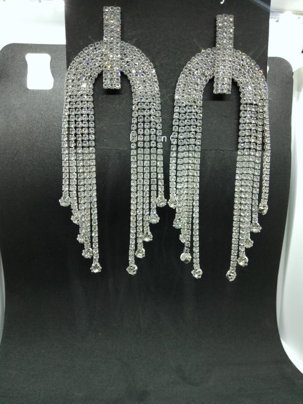 "Silver N-shaped tassel earrings inlaid with crystals hanging elegantly."