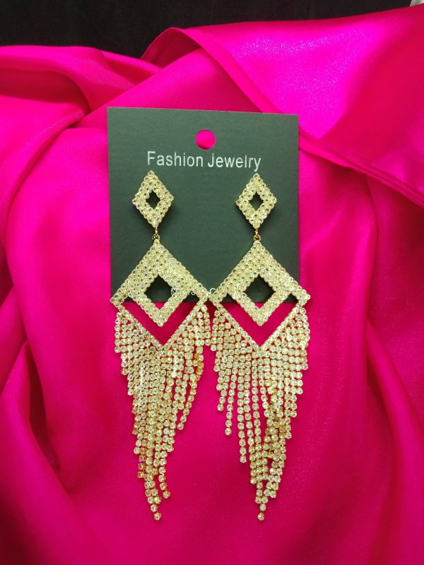 Golden earrings with diamond-cut stones reflecting light