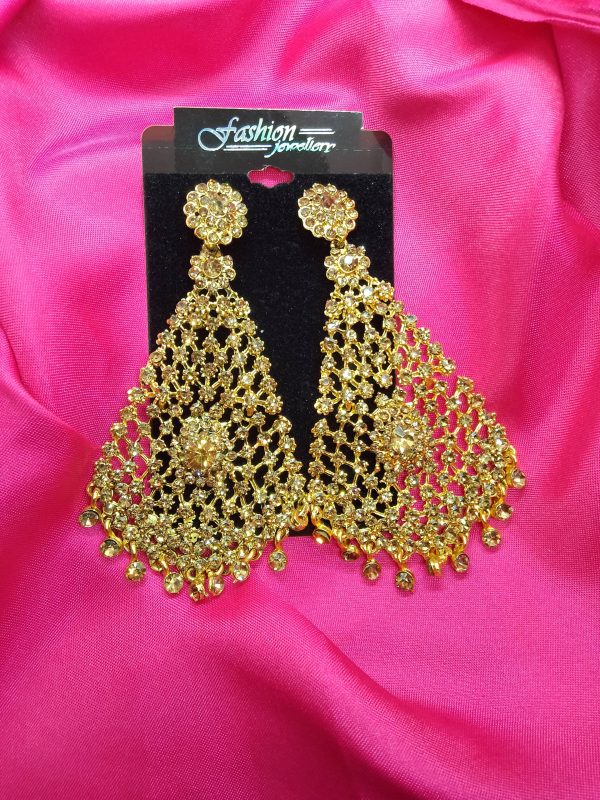 "Golden earrings with diamond cut stones hanging elegantly."